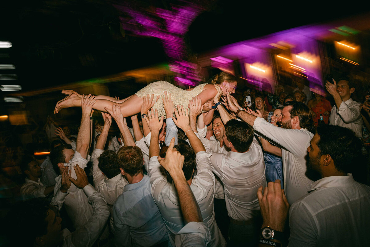 A bride crowd surfs at her wedding reception in Jamaica at Round Hill Resort