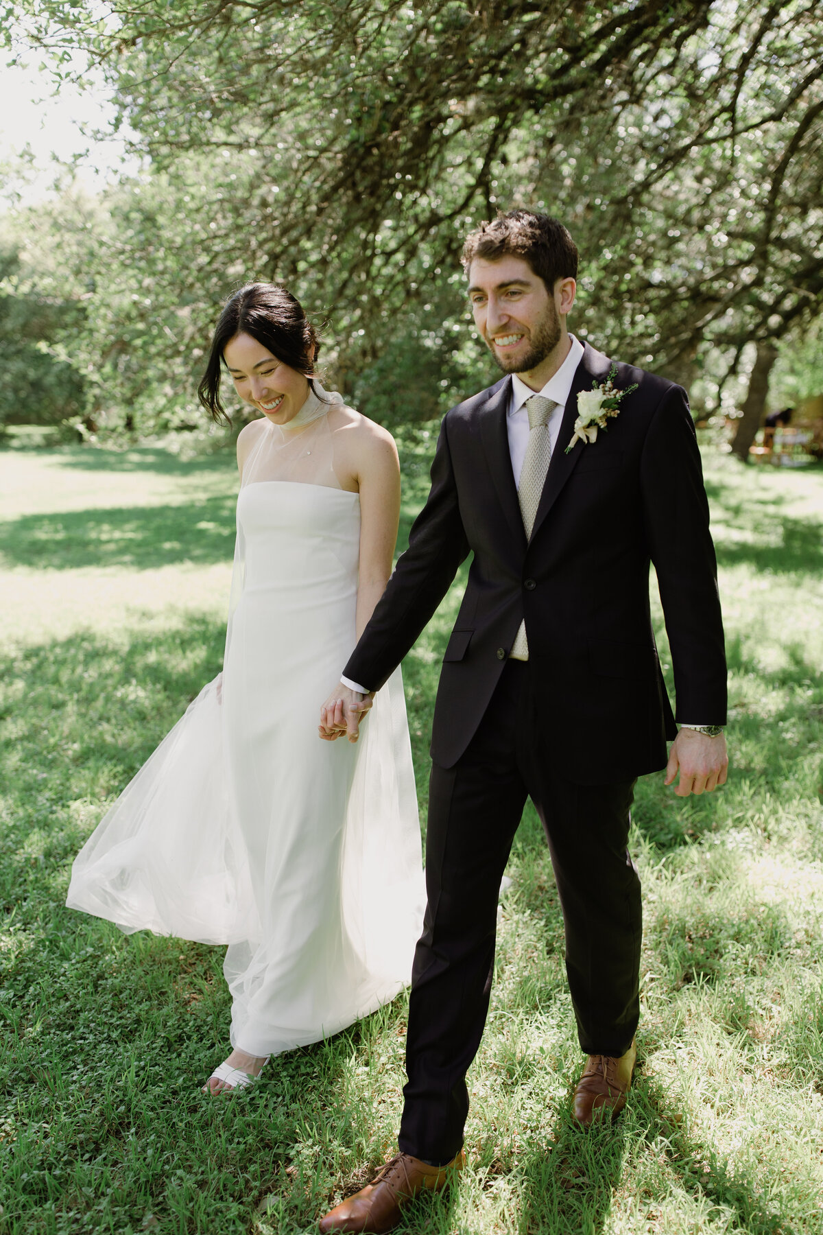 Bride and groom walking along holding hands at Mattie's  Austin Wedding