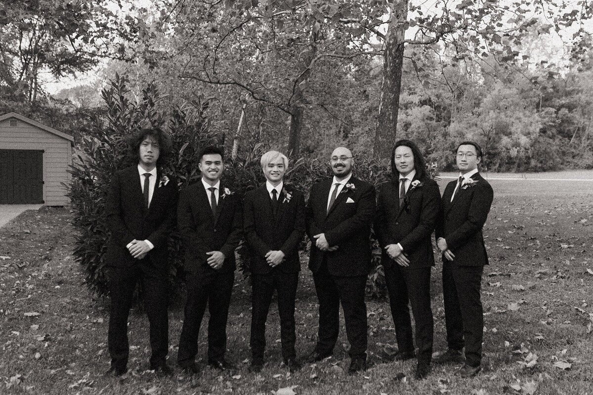 Photo of groom and groomsmen holding their hands