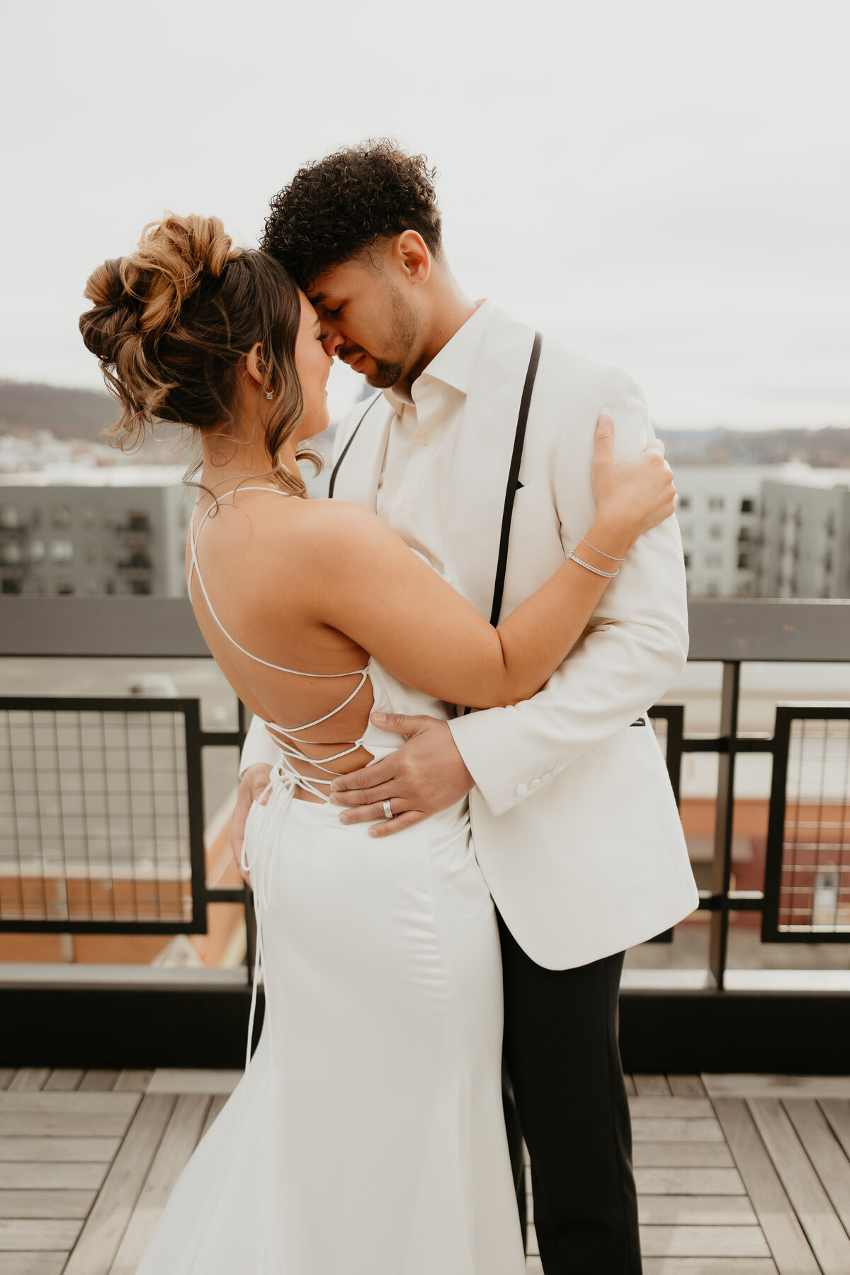 Bride and Groom Embracing over Pittsburgh in White Out Wedding