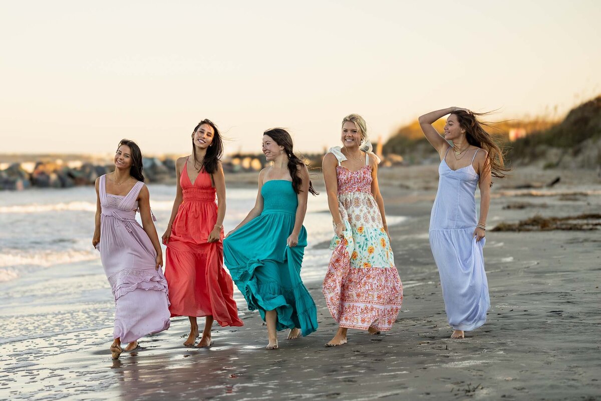 MBP Senior Team walking on the beach in long dresses in Lawrence, KS