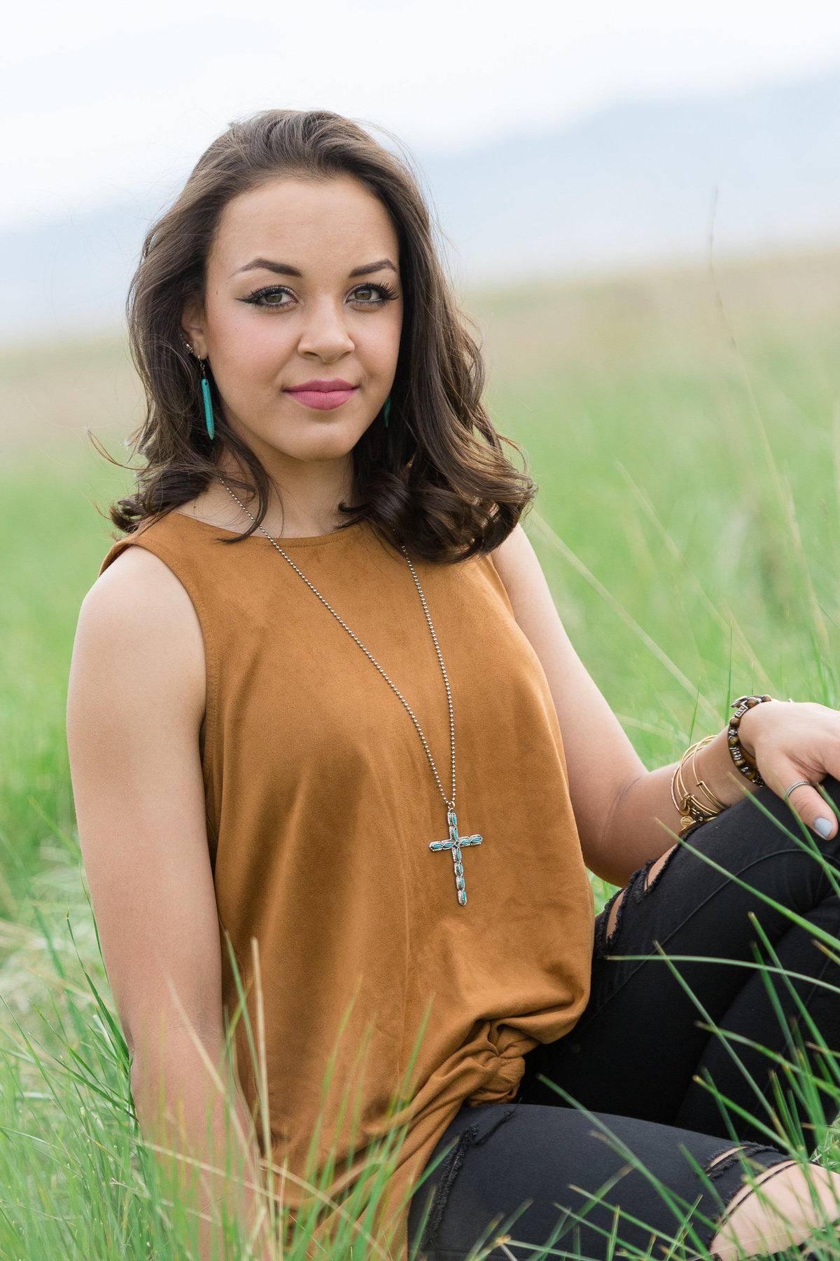 senior girls looks at the camera while sitting in the grass in layton utah