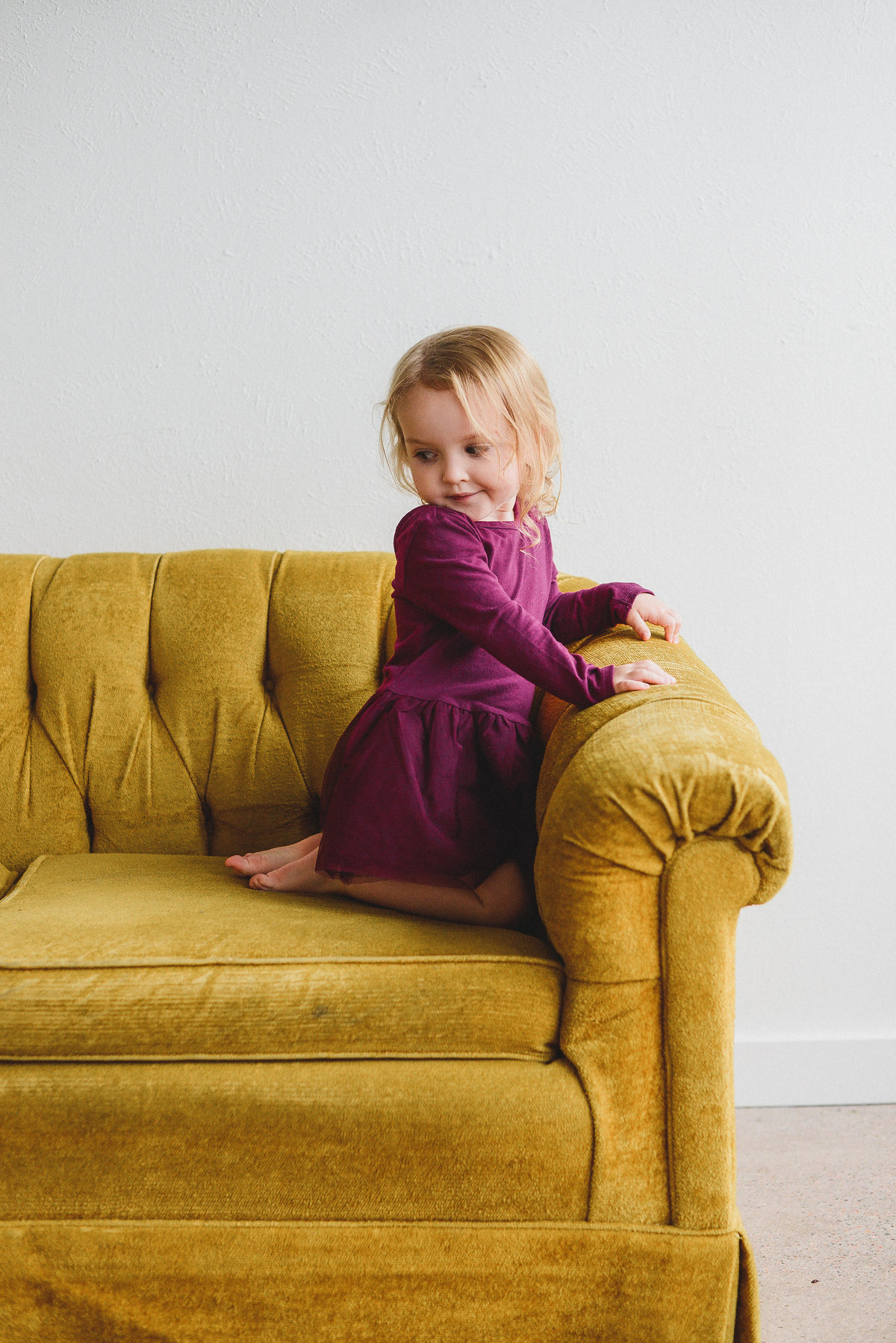 toddler girl on yellow couch