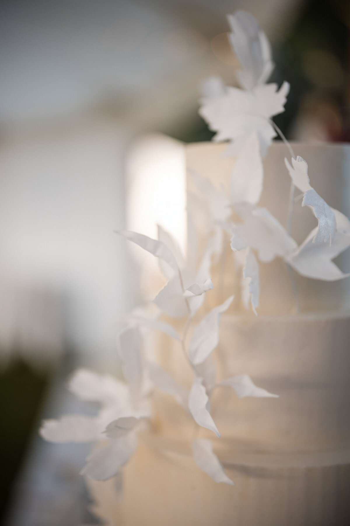 An all white delicate wedding cake at a destination wedding in Vermont