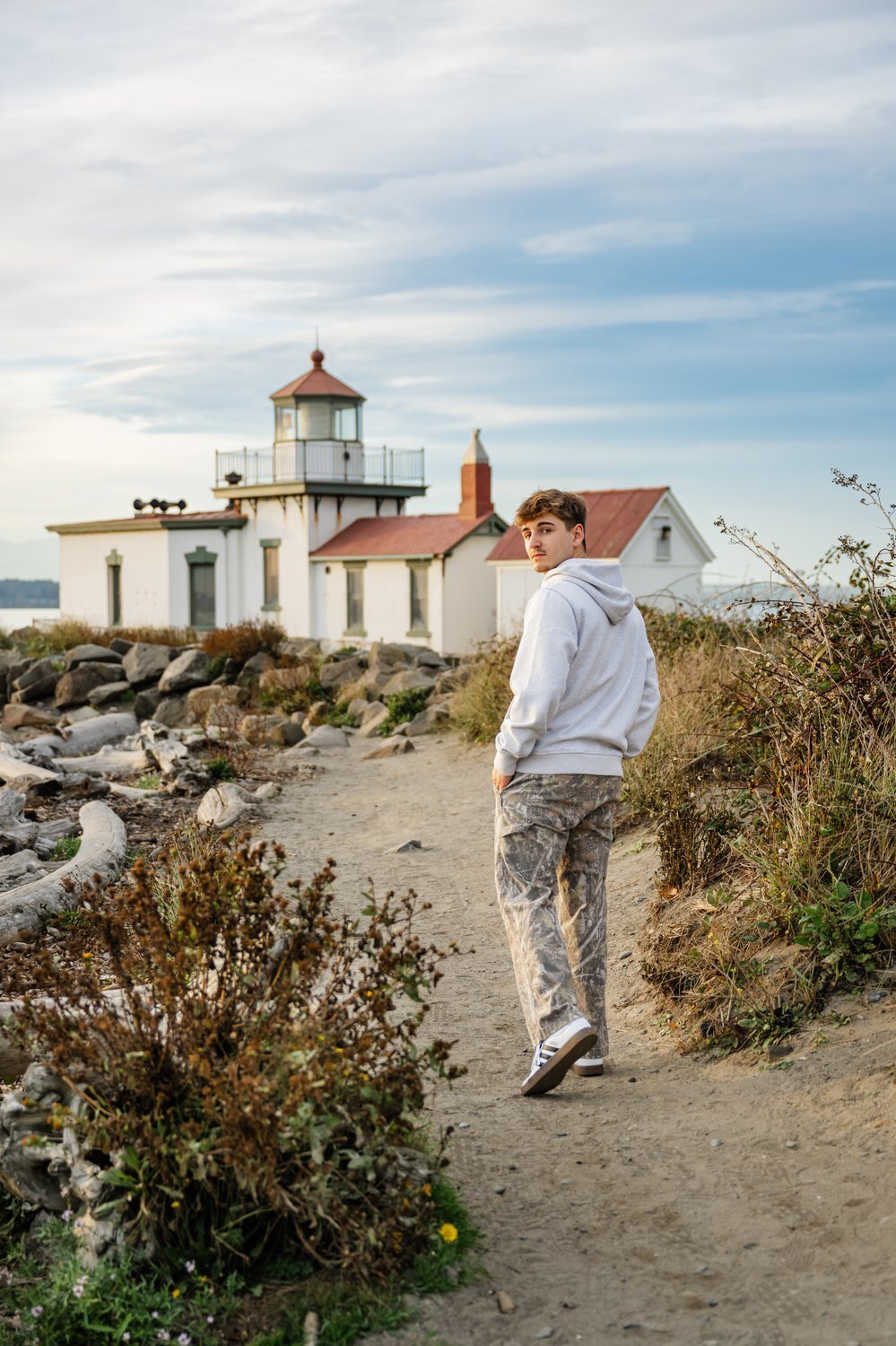 issaquah high school senior guy walking in front of seattle lighthouse
