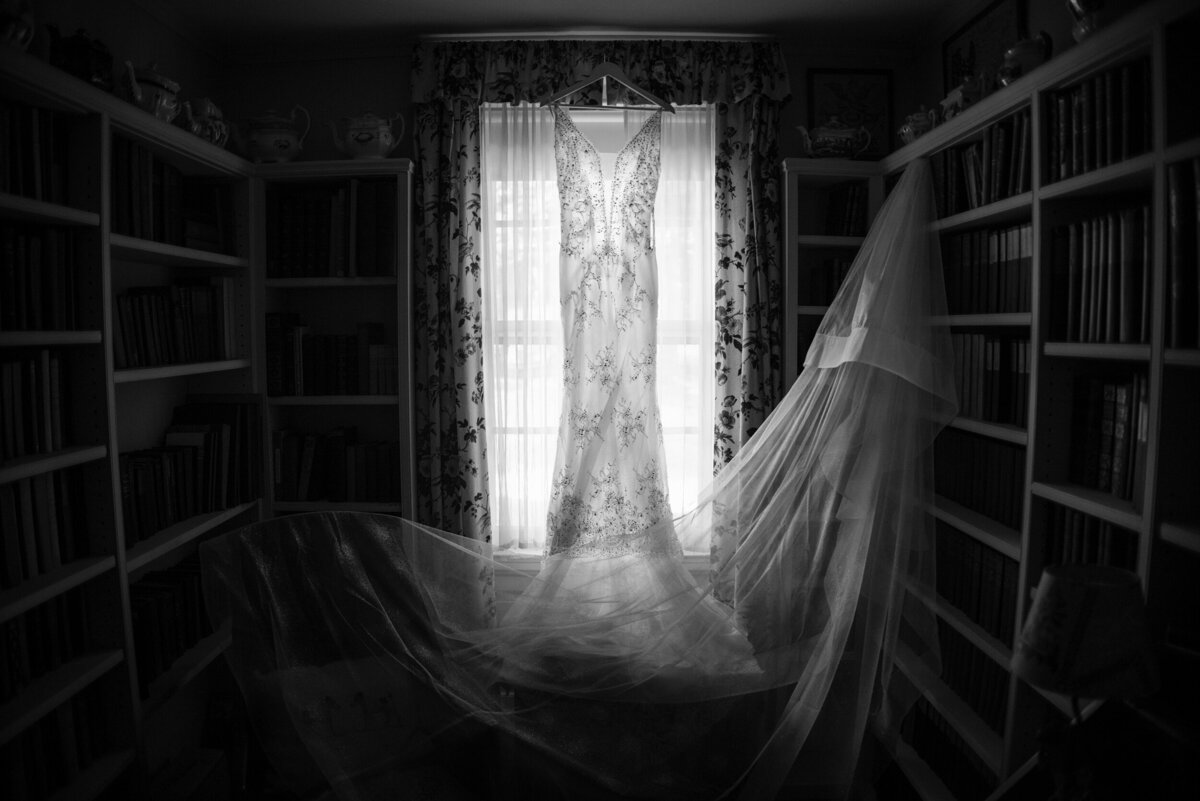 A dress hangs in a window at a destination wedding in Vermont