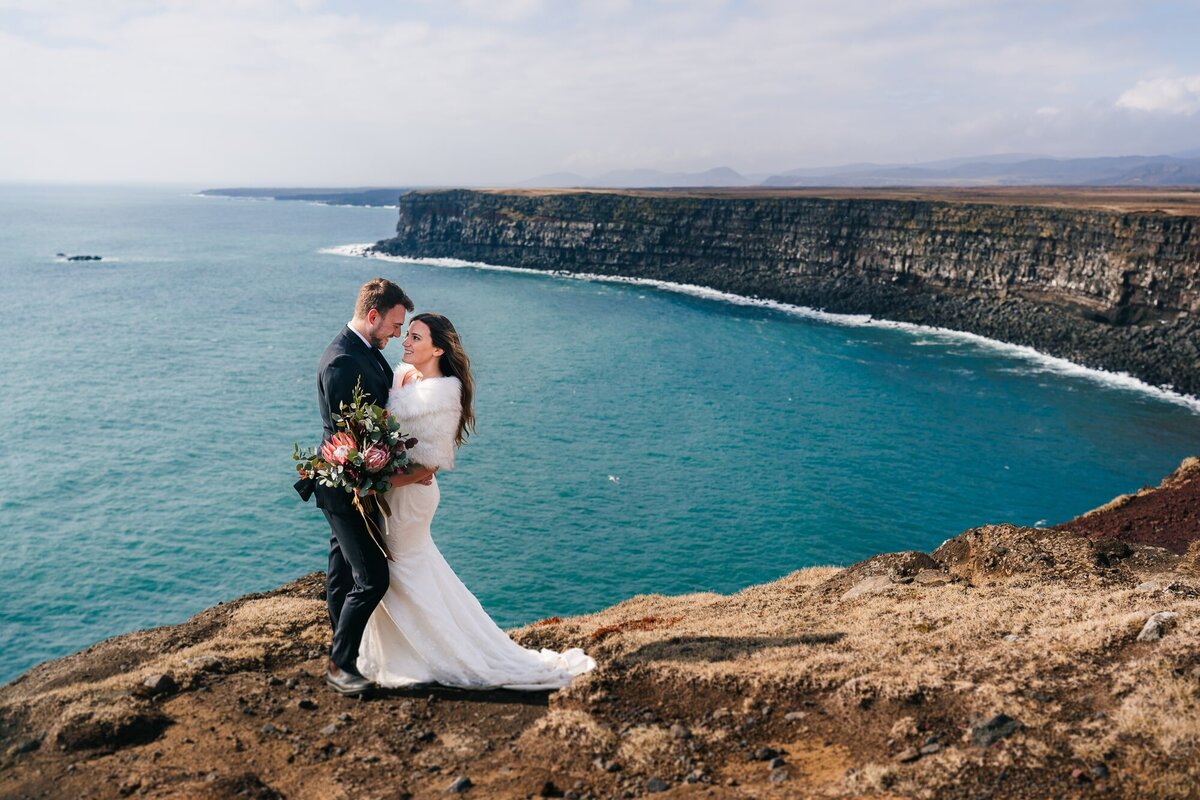 Amidst the grandeur of Krisuvikurberg cliffs in Iceland, this couple shares a profound gaze, lost in the beauty of the moment during their elopement.