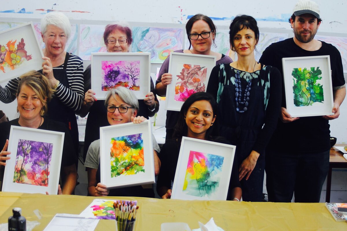Adult class holding finished ink artwork