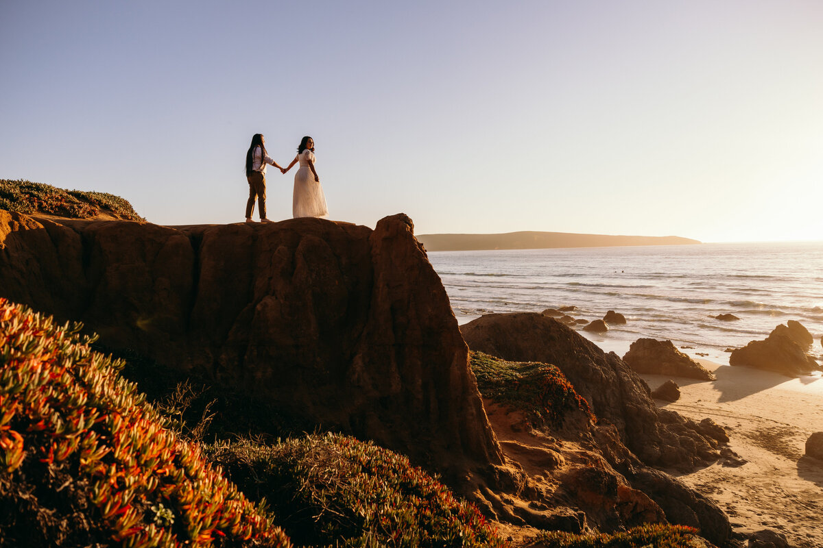 Engaged couple stands on cliff in bodega bay ca