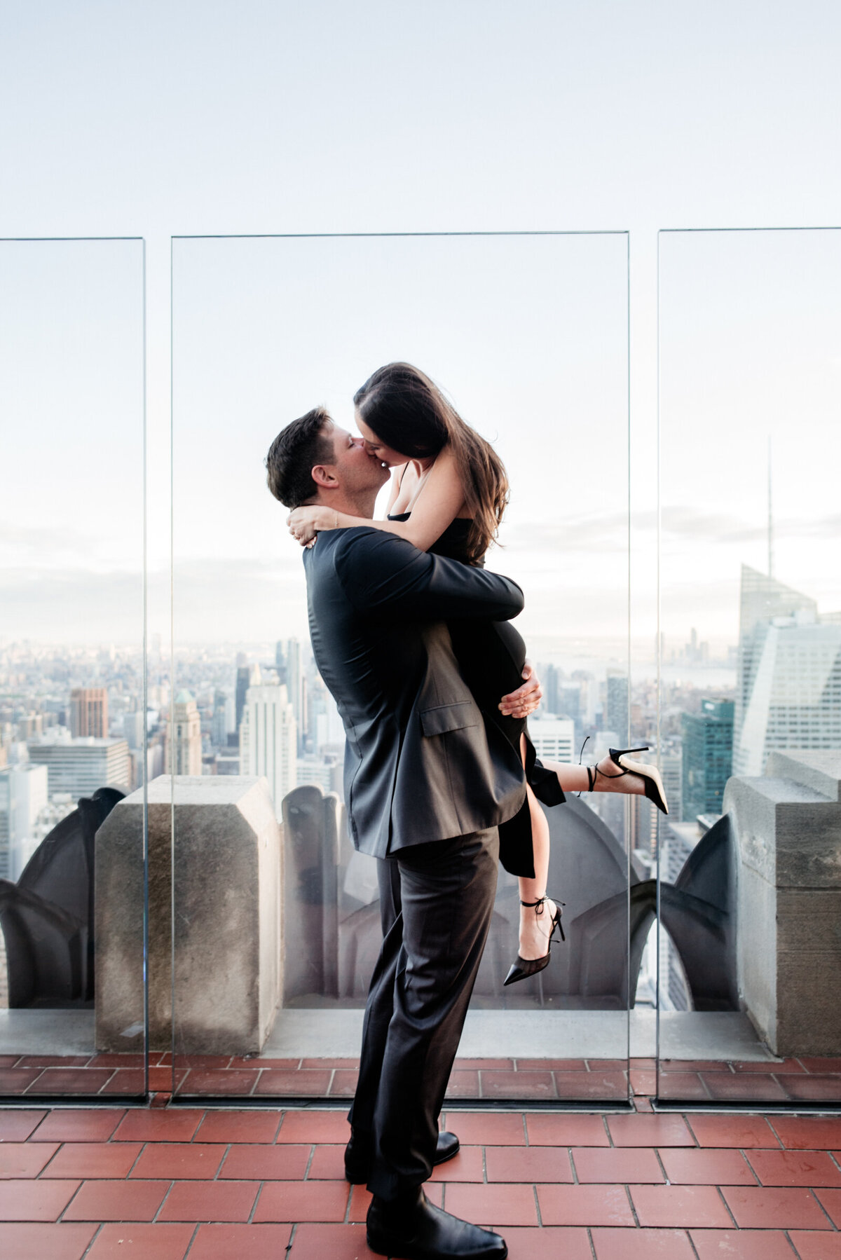 couple kissing at Top of the Rock in New York City engagement photography