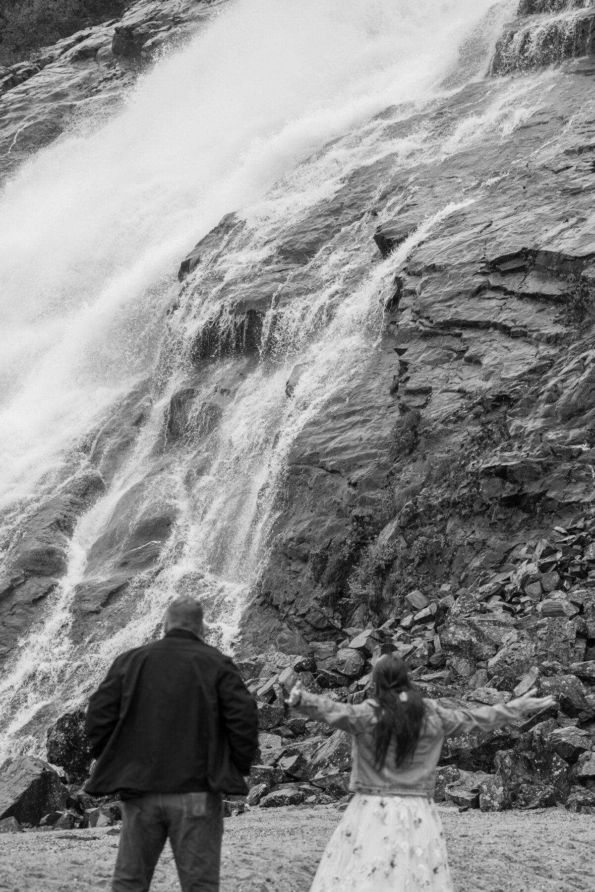 couple stand by the waterfall