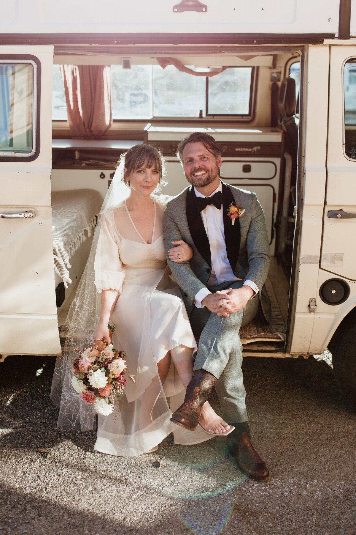 A couple in wedding attire sitting in a VW Westfalia captured by Fort Worth wedding photographer, Megan Christine Studio