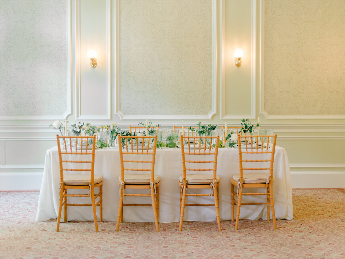 Elegant indoor wedding reception setup at Cairnwood Estate, featuring a long table with neutral linens, soft pastel floral arrangements, and classic Chiavari chairs. Captured by Elizabeth Kane Photography, a Philadelphia Fine Art Wedding Photographer, this editorial highlights timeless table styling for refined East Coast weddings.