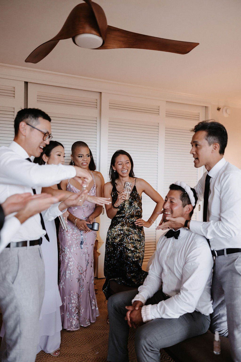 Chinese wedding game  groom having facial done by groomsmman with bridesmaids watching