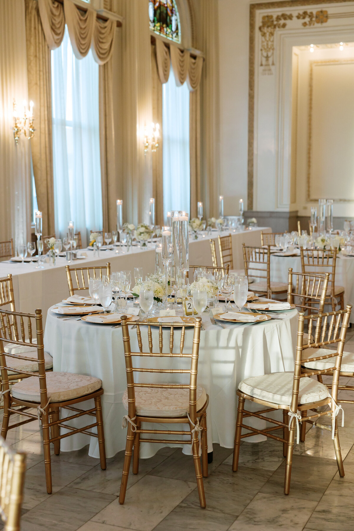 Reception table setup with gold chairs and candlelight by Philadelphia wedding photographer.