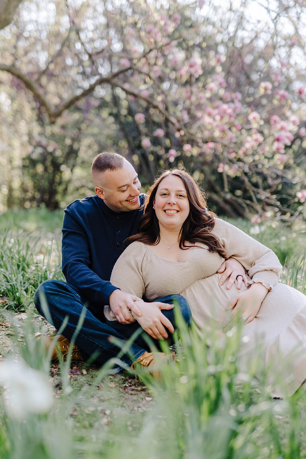 Couple laying in grass at  Finger Lakes Maternity session