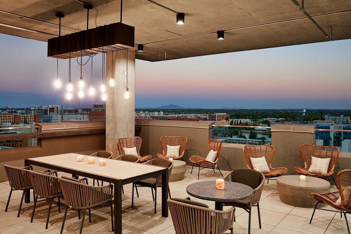 Image of the rooftop terrace that has views of the horizon, table seating, and low chair seating