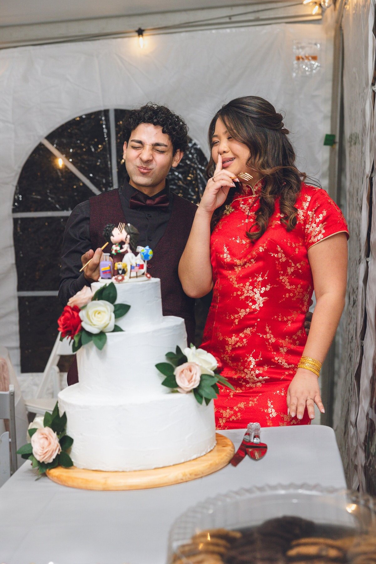 Playful cake cutting moment with the bride and groom celebrating.