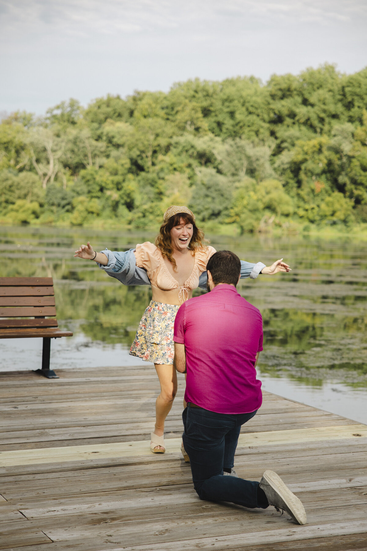 A person is down on their knee proposing to their partner who is excited.