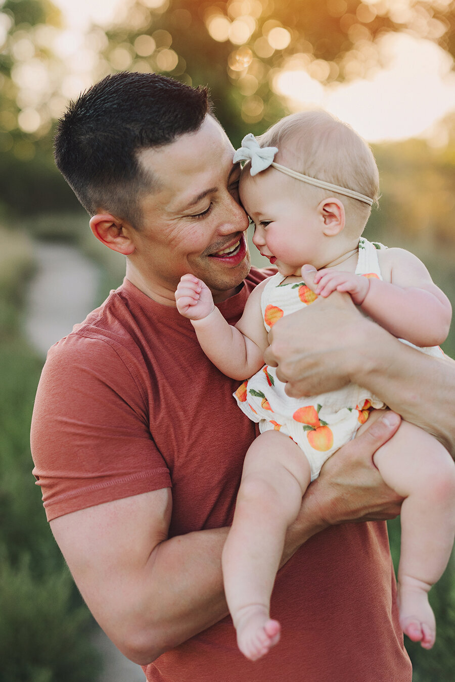 Daughter snuggling with dad in the sunset