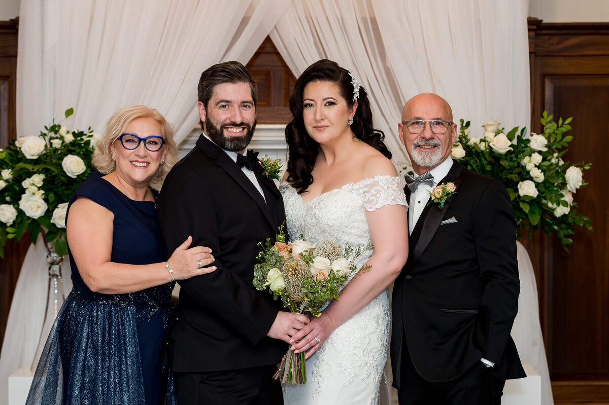 a bride and groom pose with their parents for their Ottawa wedding photography at the Chateau Laurier hotel