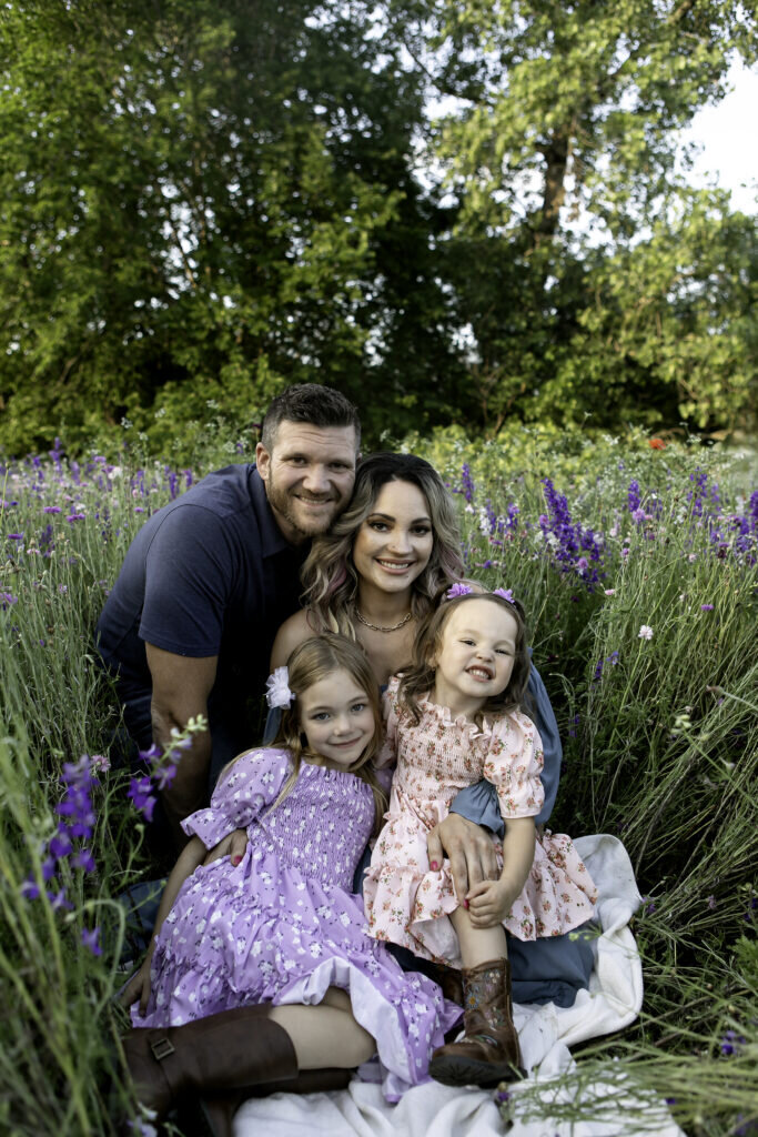 A joyful family striking playful poses and sharing smiles during their photoshoot, creating timeless memories in wildflowers