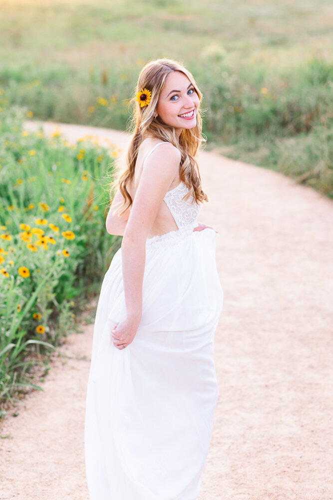 Josie wearing a long white dress  in a field.