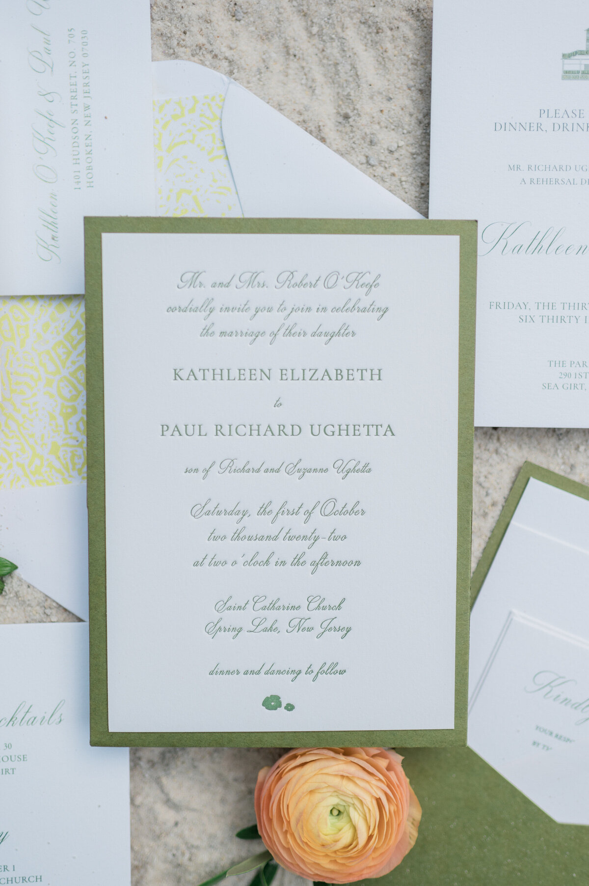 A wedding invitation displayed on a textured surface with floral and lace elements in the background. 