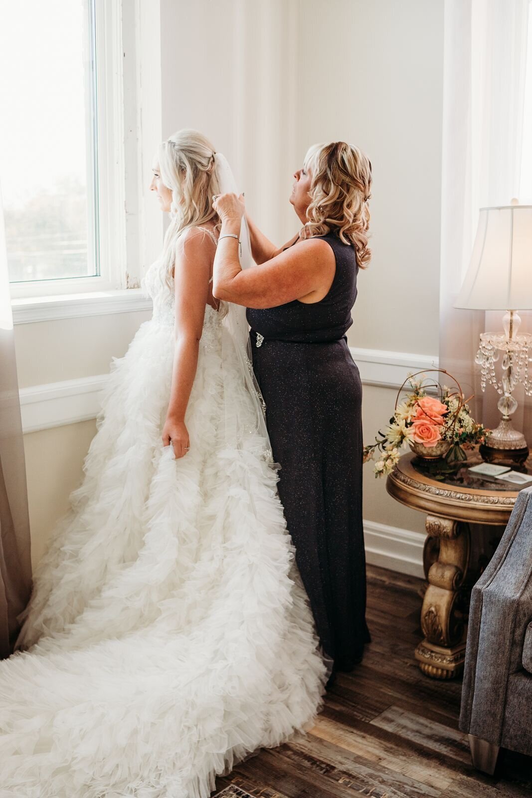 mom of the bride put the veil on the bride