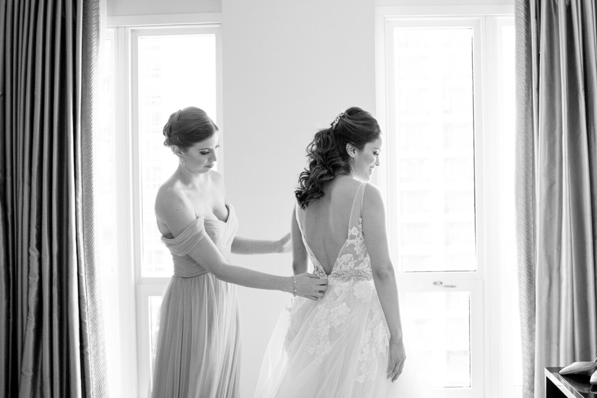 Bride getting dressed in her Vera Wang gown at the Waldorf Hotel in Chicago, Illinois