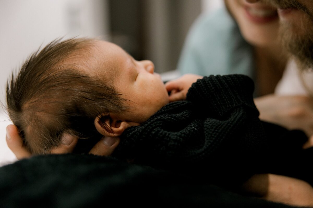 side profile of newborn in a black sweater