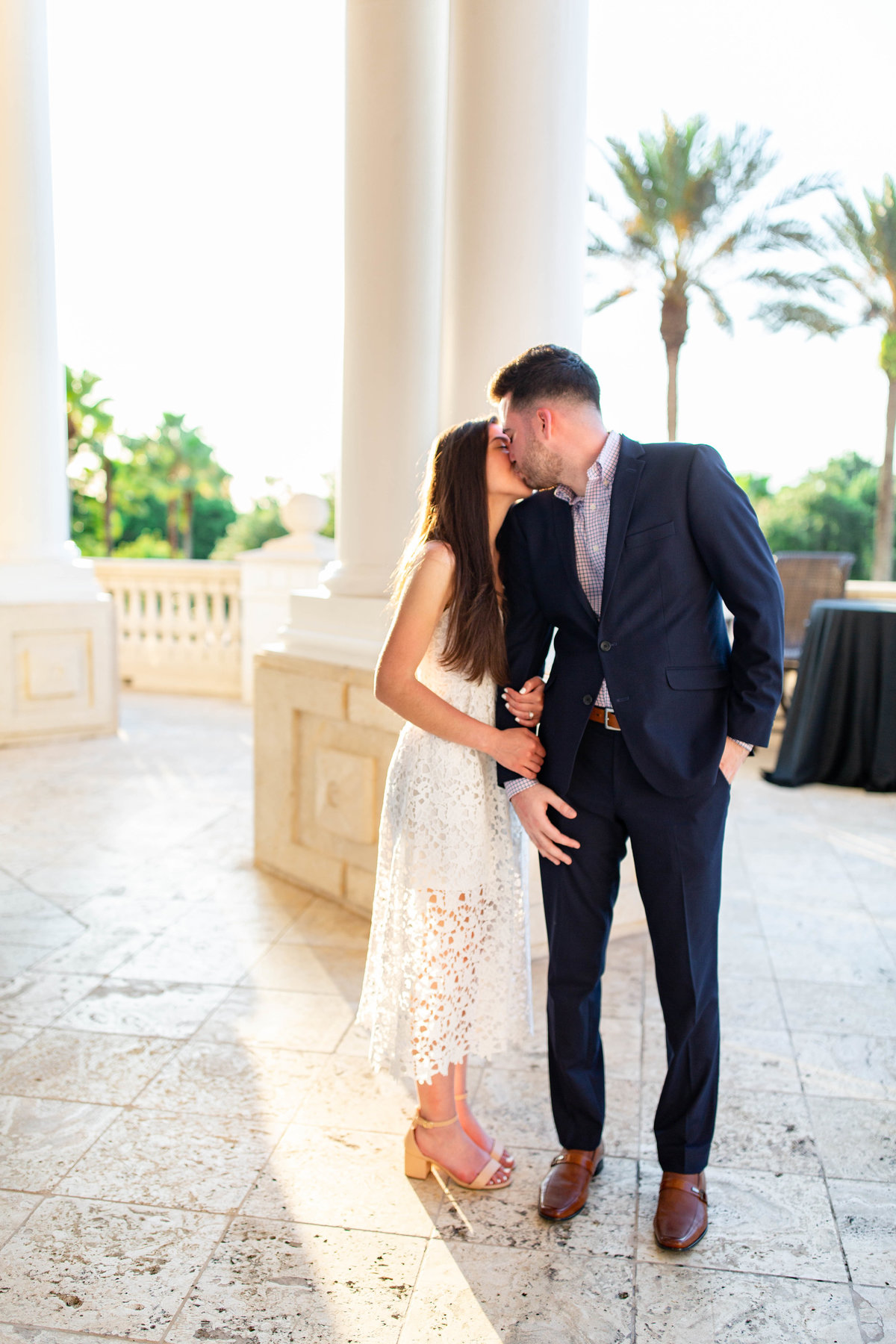 Couple shares kiss at sunset at white and marble venue in Davenport, Florida at their destination engagement session