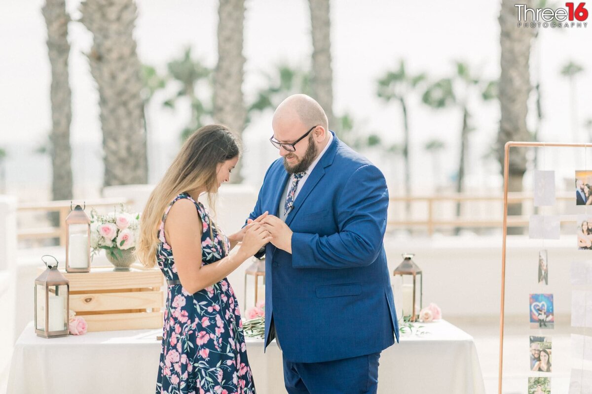 Groom to be places a ring on his fiance's finger