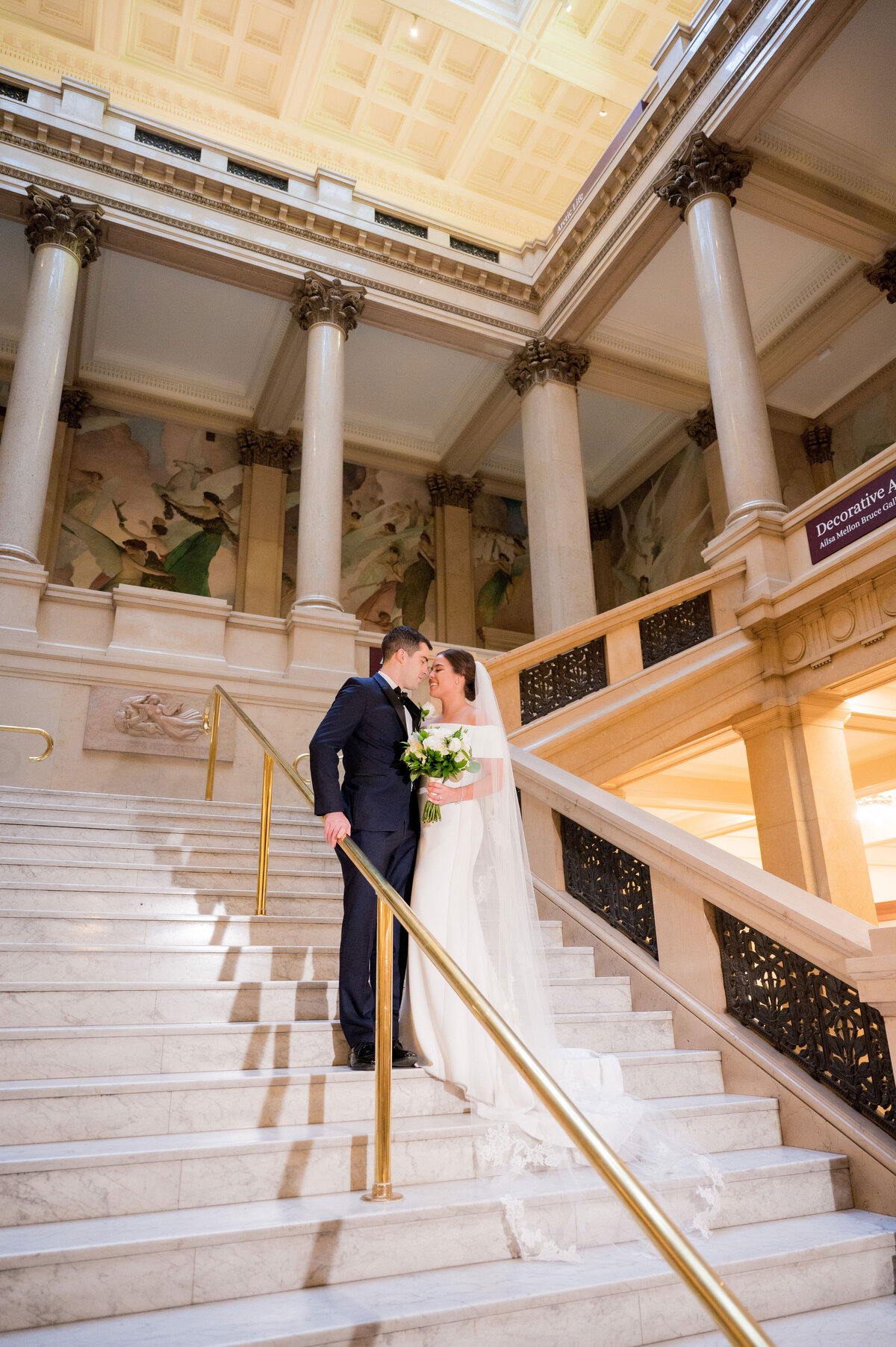 couple kissing on the staircase at carnegie museum