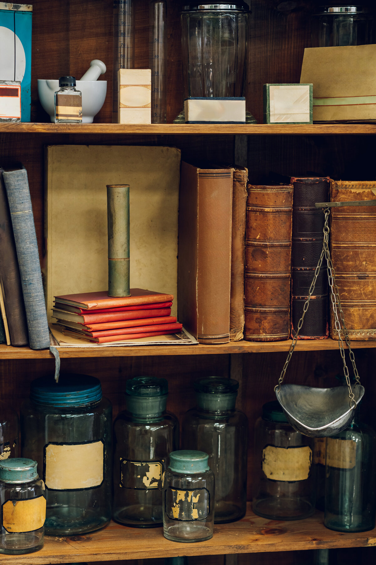 vintage-books-and-jars-on-a-shelf-in-an-apothecary-2023-11-27-05-09-18-utc