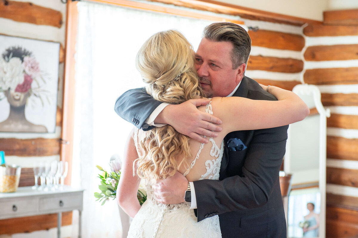 Ottawa wedding photography showing the emotional hug between a bride and her father at Stonefields Estate wedding venue.
