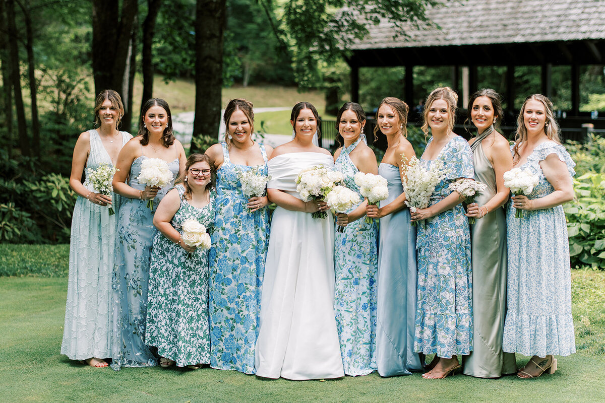 Bridesmaids in mixed blue floral dresses standing with bride at an elegant spring mountain wedding in Cashiers North Carolina.