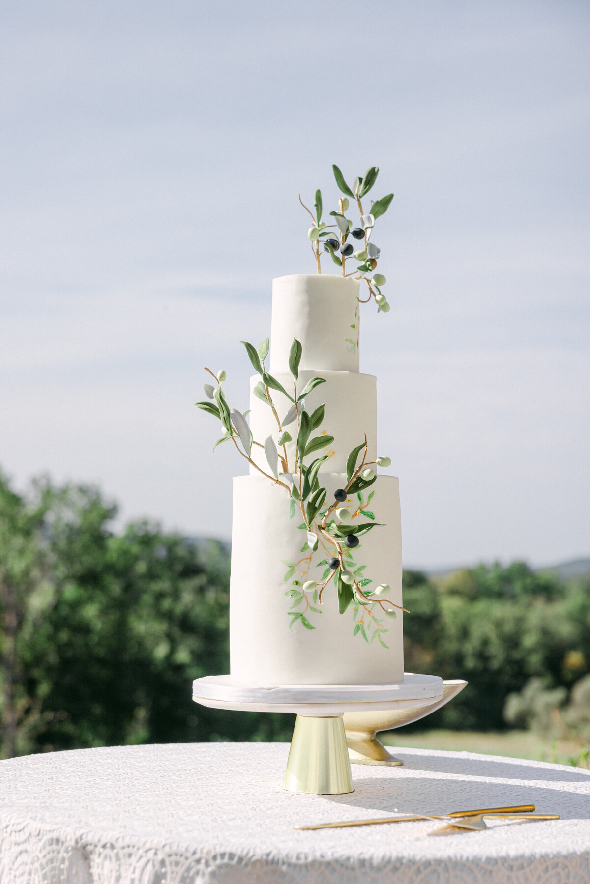 a white wedding cake decorated with greenery