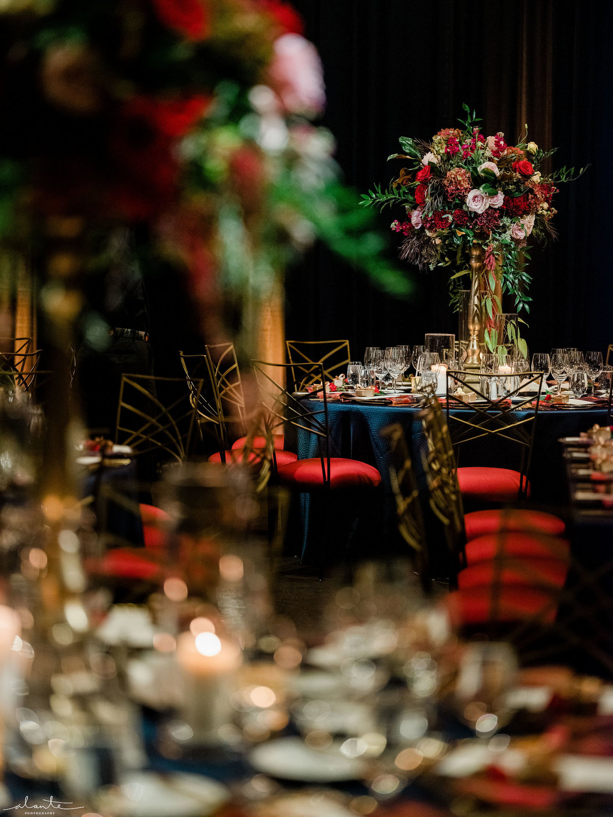 tall centerpieces at winter wedding with red chairs, navy blue linen