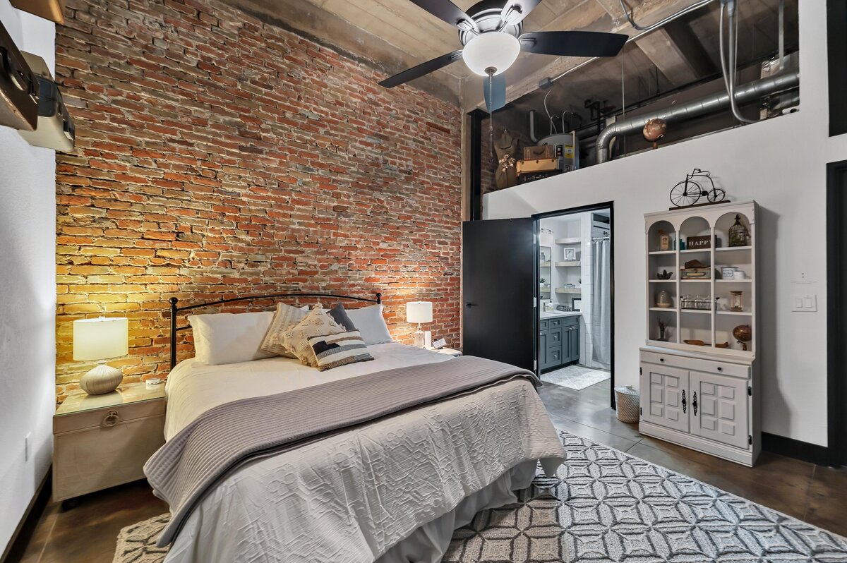 Spacious bedroom in this three-bedroom, two-bathroom industrial vacation rental loft with free WiFi, skyline view, and fully stocked kitchen in downtown Waco, Tx