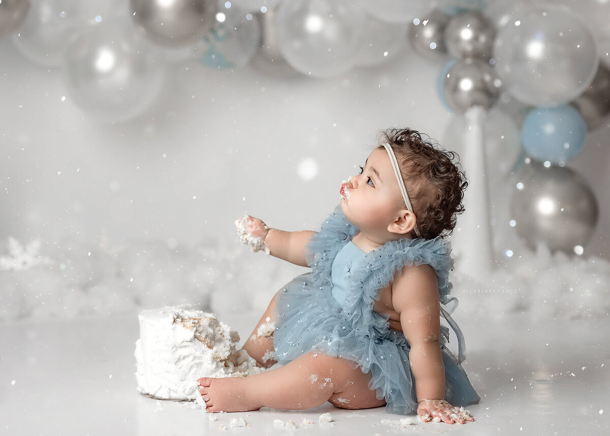 syracuse new york photographer captures first birthday cake smash with kissing face, blue and silver balloons