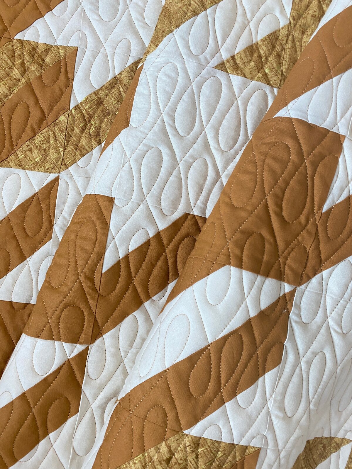 gold and white quilt features the crazy 8s quilting design
