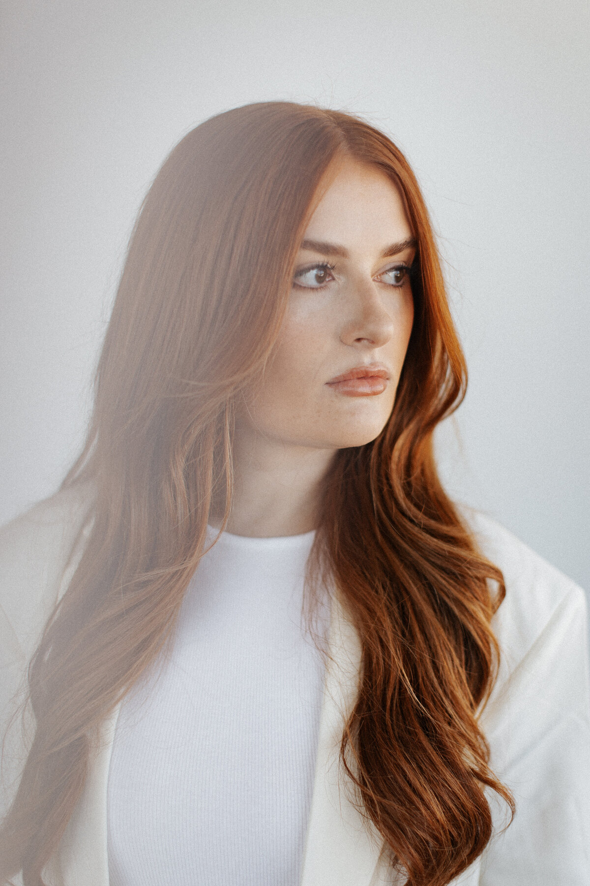 Close-up of a red-haired model shot for a salon brand, showcasing vibrant hair and modern styling for branding visuals.