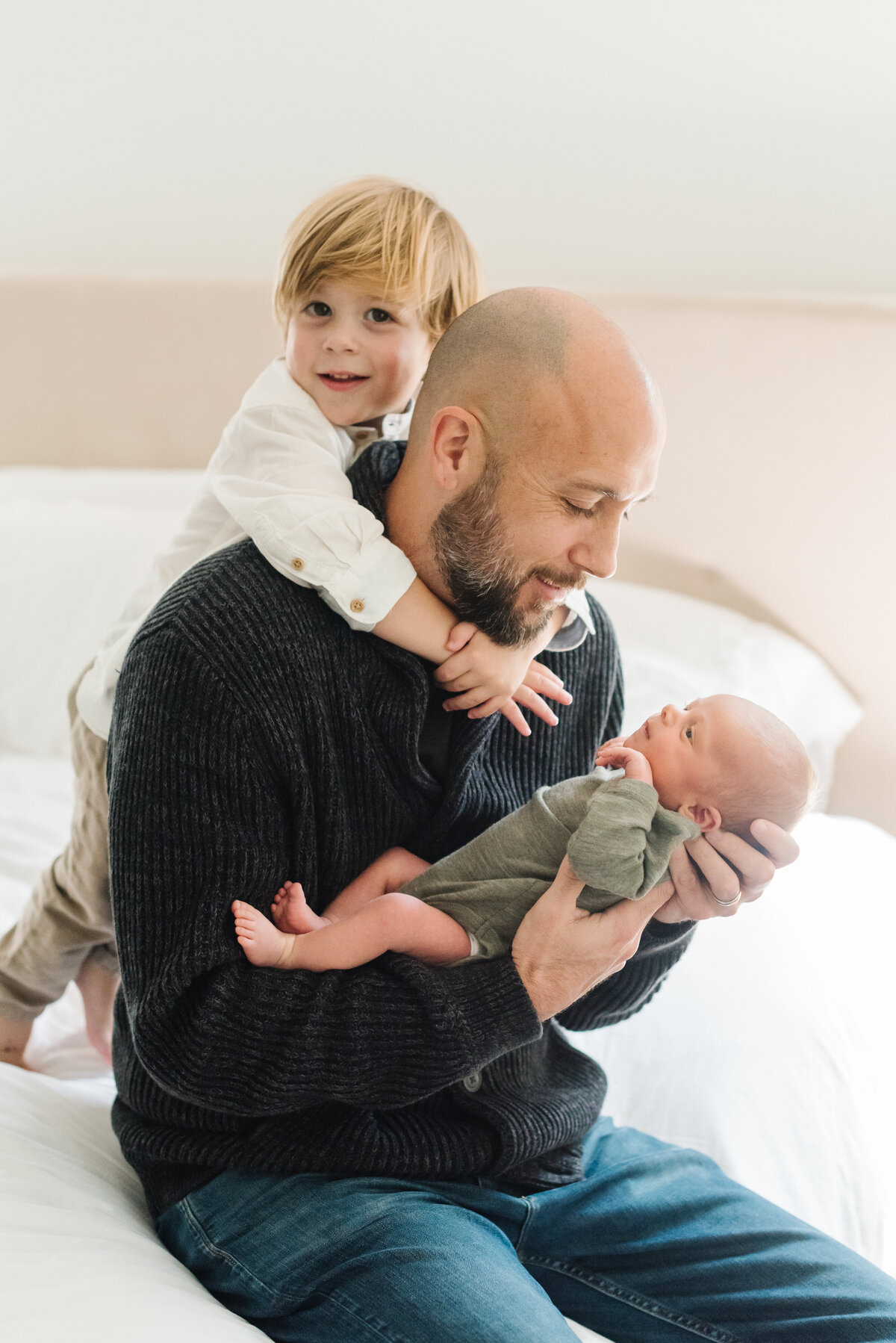Dad looking at newborn with toddler hugging from behind - Northern Virginia Newborn Photographer