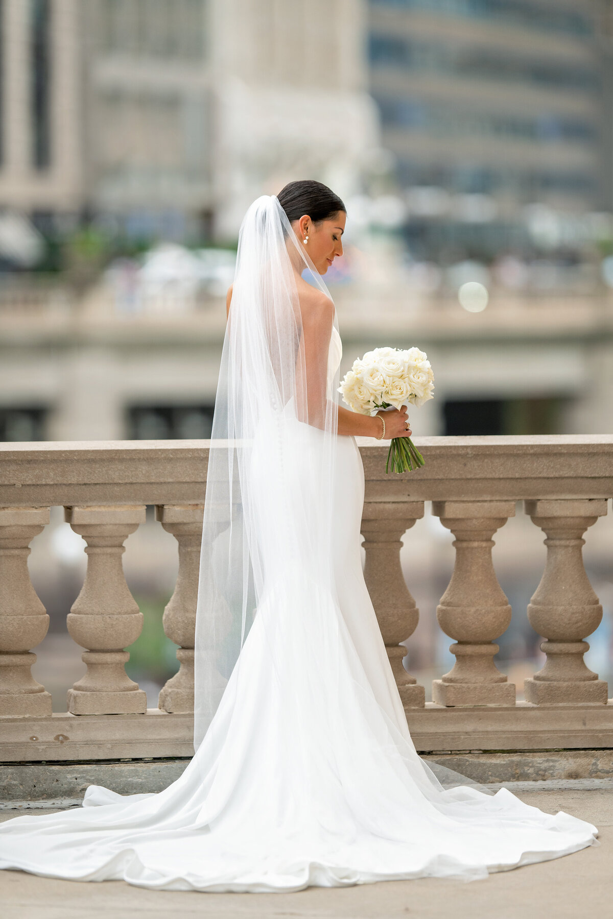 Beautiful Chicago bride looking down at her wedding flowers 