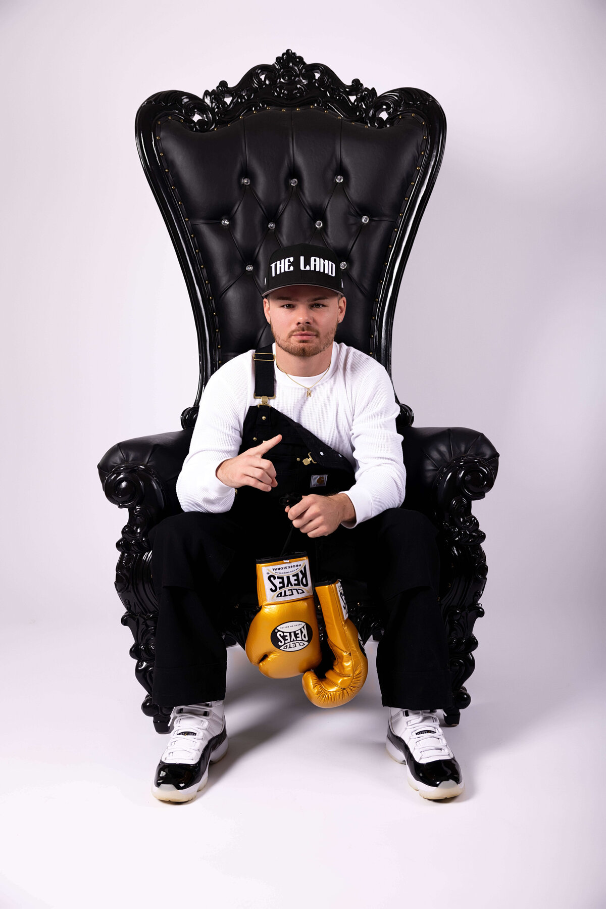 Professional boxer sitting in chair with boxing gloves in birthday session with Reva Davis photography
