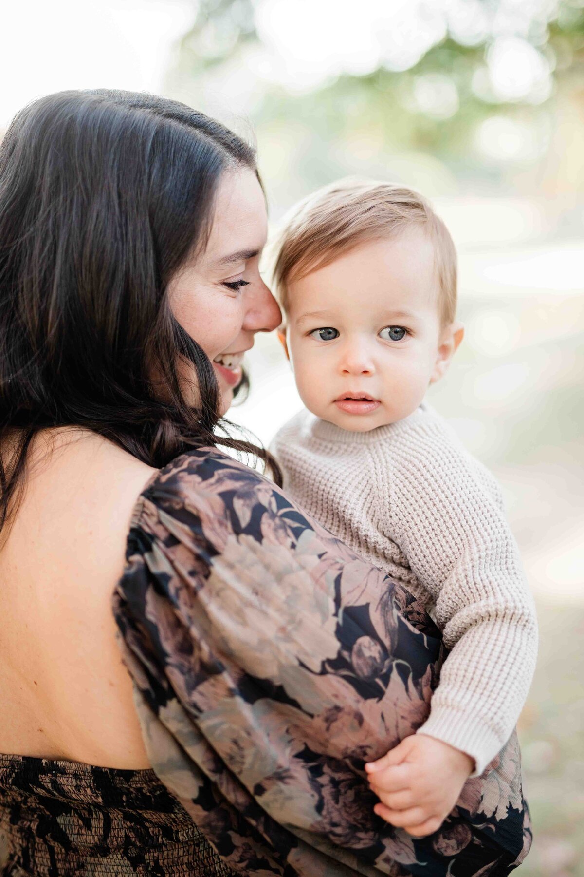 Mom snuggling her newborn son over her shoulder in a sentimental moment