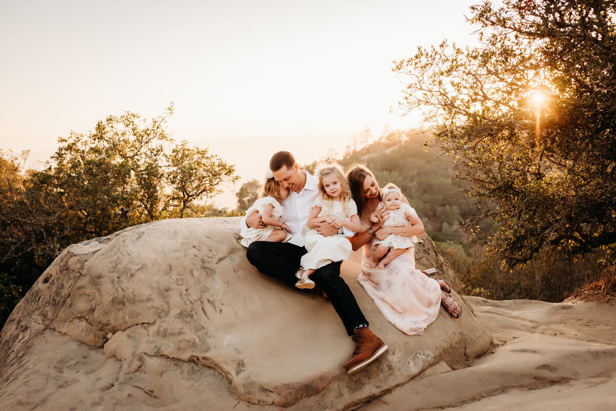 Family snuggled on the rocks in Rock City, Mt. Diablo