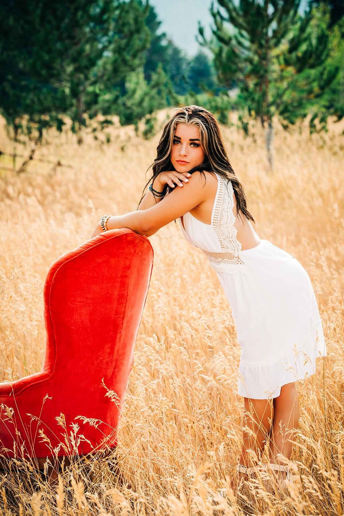 Missoula senior photo of girl standing in field with chair