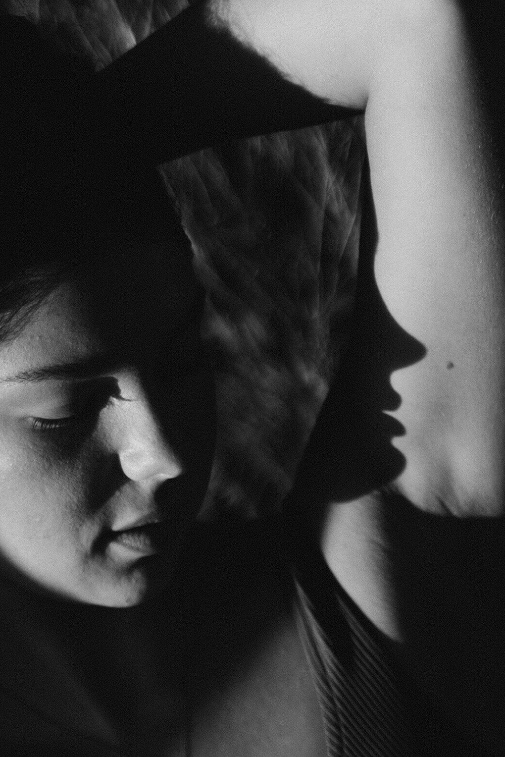 creative close up portrait of a swimwear model in black and white with shadow reflection of her face. Captured by Sunshine Coast brand photographer